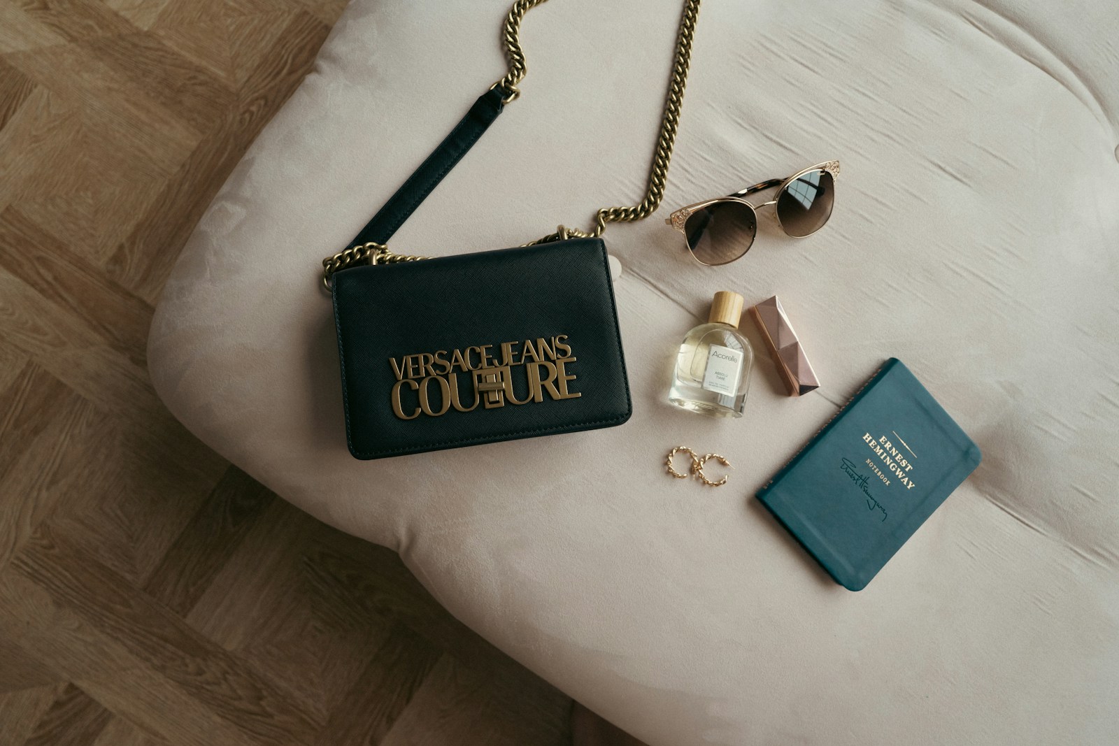 a purse, sunglasses, and a book on a bed