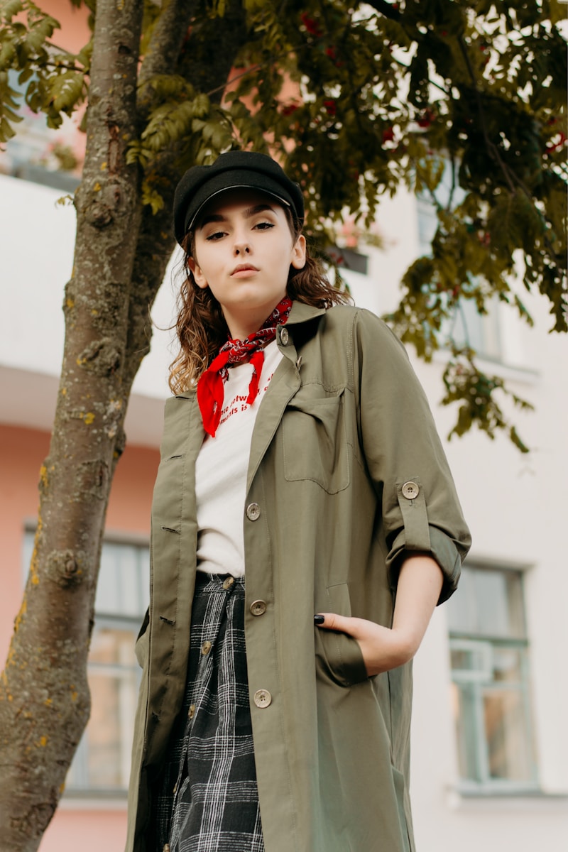 a woman standing next to a tree wearing a hat