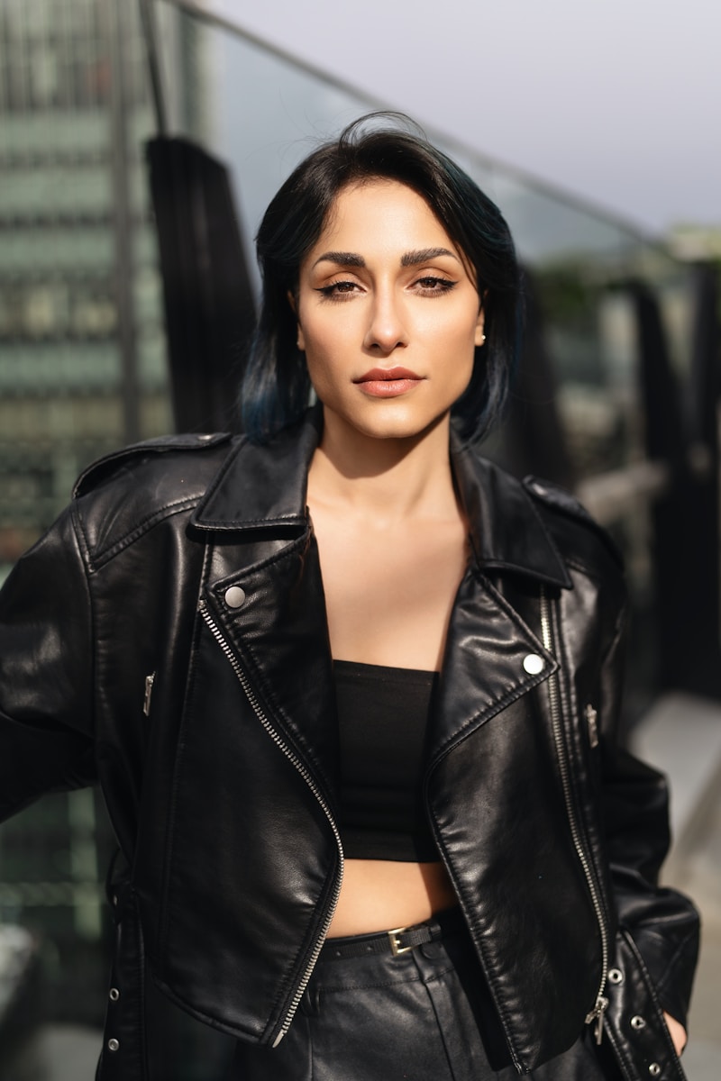 A woman wearing a black leather jacket and skirt